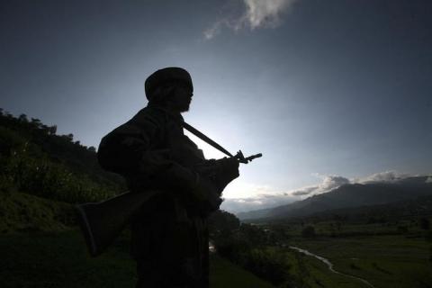 An Indian army soldier stands guard while patrolling near the Line of Control, a ceasefire line dividing Kashmir between India and Pakistan, in Poonch district