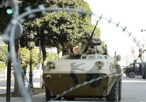 An army soldier stands guard behind a wire fence cordon outside the interior minister's office in Tunis, February 7, 2011. PHOTO BY REUTERS/Zoubier Souissi