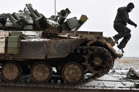 A Ukrainian serviceman jumps off a tank damaged during fighting with pro-Russian separatist forces, as it stays on a towing truck outside Debaltseve, eastern Ukraine, February 10, 2015. PHOTO BY REUTERS/Alexei Chernyshev