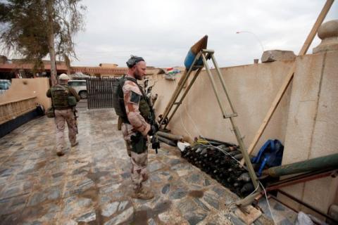 A U.S. soldier looks at weapons and ammunition belonging to Islamic State militants in the town of Bashiqa, east of Mosul, Iraq, December 14, 2016. PHOTO BY REUTERS/Azad Lashkari