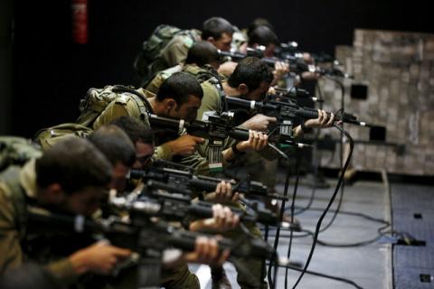 Israeli soldiers respond with laser-firing rifles to a simulated Palestinian attack playing out on an interactive screen, during an open-fire scenario training in Camp Tsur infantry training base in southern Israel, near Yeruham, March 24, 2016. PHOTO BY REUTERS/Amir Cohen