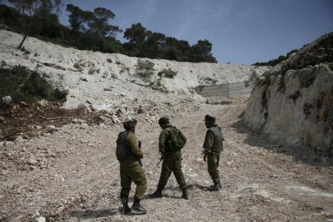 Israeli soldiers observe the area where the Israeli army is excavating part of a cliff to create an additional barrier along its border with Lebanon, near the community of Shlomi in northern Israel, April 6, 2016. PHOTO BY REUTERS/Ronen Zvulun
