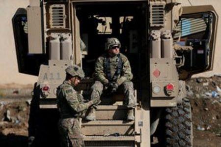 US army soldiers sit next a military vehicle in the town of Bartella, east of Mosul, Iraq, December 27, 2016. PHOTO BY REUTERS/Ammar Awad
