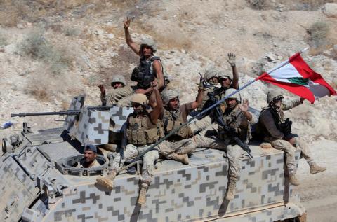 Lebanese army soldiers gesture as they sit on their military vehicles in the town of Ras Baalbek, Lebanon, August 21, 2017. PHOTO BY REUTERS/ Ali Hashisho