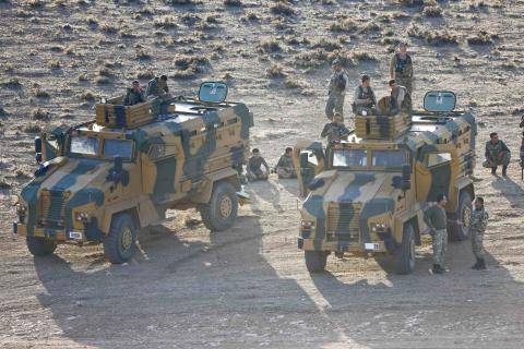 Turkish soldiers are seen atop and around armoured vehicless near the Mursitpinar border crossing on the Turkish-Syrian border in the southeastern town of Suruc in Sanliurfa province