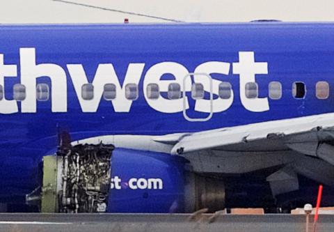 Emergency personnel monitor the damaged engine of Southwest Airlines Flight 1380, which diverted to the Philadelphia International Airport this morning after the airline crew reported damage to one of the aircraft's engines, on a runway in Philadelphia, Pennsylvania U.S., April 17, 2018. PHOTO BY REUTERS/Mark Makela