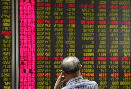 A man watches a board showing stock prices at a brokerage office in Beijing, China, July 6, 2015. PHOTO BY REUTERS/Kim Kyung-Hoon