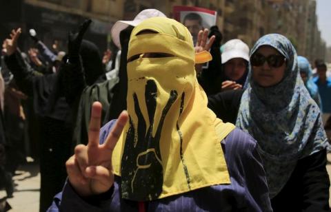 A supporter of the Muslim Brotherhood and deposed Egyptian President Mohamed Mursi wears a face veil depicting the Rabaa sign during a rallY near Giza square, south of Cairo, Egypt, June 19, 2015. PHOTO BY REUTERS/Amr Abdallah Dalsh