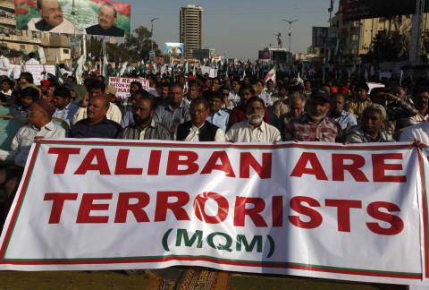 Supporters of Pakistan's Muttahida Quami Movement (MQM) political party hold a banner as they listen to speeches from their leaders during a rally to show their solidarity to Pakistan's armed forces in Karachi