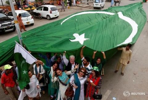 Supporters of civil rights group for transgender people, the Gender Interactive Alliance (GIA), dance and chant slogans as they pose with a national flag ahead of the Independence Day in Karachi, Pakistan, August 13, 2016. PHOTO BY REUTERS/Akhtar Soomro
