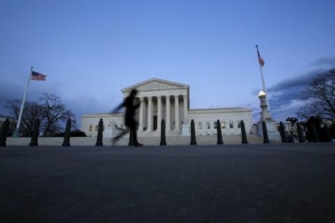 A woman walks past the Supreme Court building at Capitol Hill in Washington D.C., February 13, 2016. PHOTO BY REUTERS/Carlos Barria
