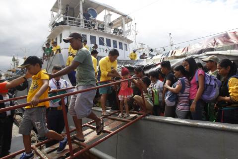 Survivors of super Typhoon Haiyan disembark from a Philippine Navy ship upon arrival at the north harbor in Manila