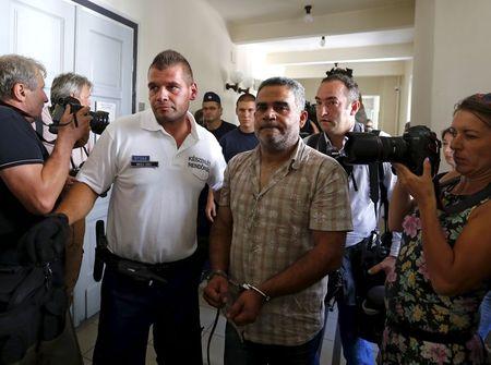 Police escort suspects in the deaths of 71 refugees found in a truck on an Austrian motorway, in Kecskemet, Hungary, August 29, 2015. PHOTO BY REUTERS/Laszlo Balogh