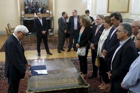 Greek Prime Minister Alexis Tsipras (2nd L) looks on as Greek President Prokopis Pavlopoulos (L) leads a swearing in ceremony under political oath of newly appointed members of the government at the Presidential Palace in Athens, Greece, July 18, 2015. PHOTO BY REUTERS/Alkis Konstantinidis