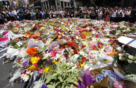 Members of the public look at thousands of floral tributes placed near the cafe in central Sydney, December 16, 2014 where hostages were held for over 16-hours. PHOTO BY REUTERS/David Gray