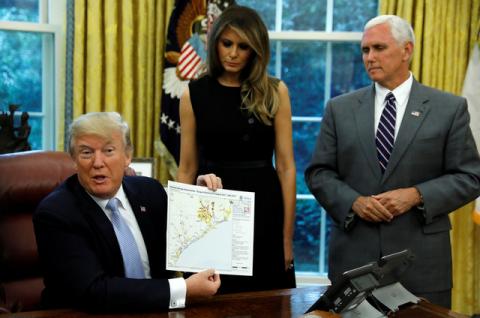 U.S. first lady Melania Trump and Vice President Mike Pence stand by U.S. President Donald Trump as he holds up FEMA map of damage assessment in Texas caused by Hurricane Harvey at the White House in Washington, U.S., September 1, 2017. PHOTO BY REUTERS/Kevin Lamarque
