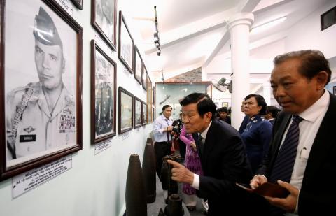 Former Vietnamese President Truong Tan Sang (C) and Deputy Prime Minister Truong Hoa Binh (R) looks at the images of U.S. soldiers who fired the villagers 50 years ago while they visit the museum during the 50th anniversary of the My Lai massacre in My Lai village, Vietnam, March 16, 2018. PHOTO BY REUTERS/Kham