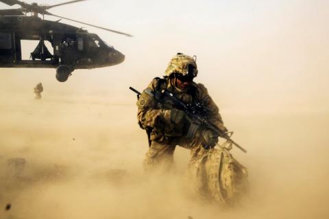 A U.S. soldier from the 3rd Cavalry Regiment shields himself from the rotor wash of a UH-60 Blackhawk helicopter after being dropped off for a mission with the Afghan police near Jalalabad in the Nangarhar province of Afghanistan, December 20, 2014. PHOTO BY REUTERS/Lucas Jackson