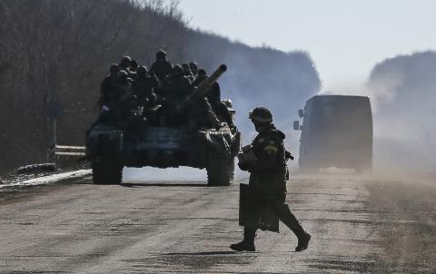 Ukrainian servicemen ride on a tank as they leave an area around Debaltseve, eastern Ukraine near Artemivsk, February 18, 2015. PHOTO BY REUTERS/Gleb Garanich