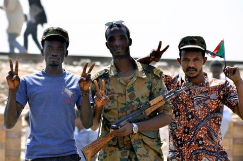 A Sudanese military officer and demonstrators gesture in celebration after Defence Minister Awad Ibn Auf stepped down. PHOTO BY REUTERS/Stringer