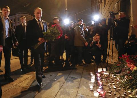 Russian president Vladimir Putin puts flowers down outside Tekhnologicheskiy Institut metro station in St. Petersburg, Russia. PHOTO BY REUTERS/Grigory Duko