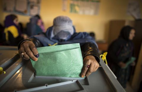 An Afghan woman casts her ballot at a polling station in Mazar-i-Sharif
