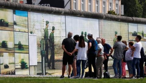 Visitors look at the art installation "Beyond The Wall" by German artist Stefan Roloff at the backside of the East Side Gallery in Berlin, Germany, August 10, 2017. PHOTO BY REUTERS/Hannibal Hanschke