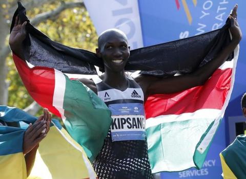 Wilson Kipsang of Kenya celebrates with his country's flag after winning the men's professional division of the 2014 New York City Marathon in Central Park in Manhattan, November 2, 2014. PHOTO BY REUTERS/Mike Segar