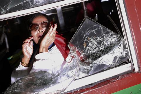 A terrified woman pleads from inside a bus as it is attacked by anti-government protesters near the stadium where pro-government red shirts are gathering in Bangkok