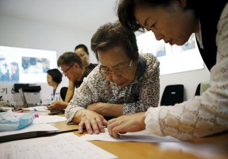 A woman who said she has family members living in North Korea gets help to prepare documents for reunion at the Red Cross building in Seoul, South Korea, September 8, 2015. PHOTO BY REUTERS/Kim Hong-Ji