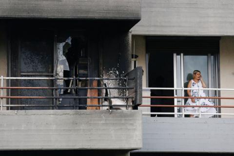 A woman speaks on the phone as she stands next to a burned apartment, following a wildfire at the village of Mati, near Athens, Greece, July 24, 2018. PHOTO BY REUTERS/Costas Baltas