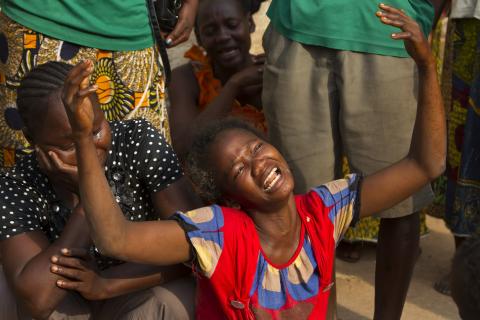 A woman reacts near the dead body of her sister who was killed during one of the latest incidents of sectarian violence in the 5th Arrondissement of the capital Bangui