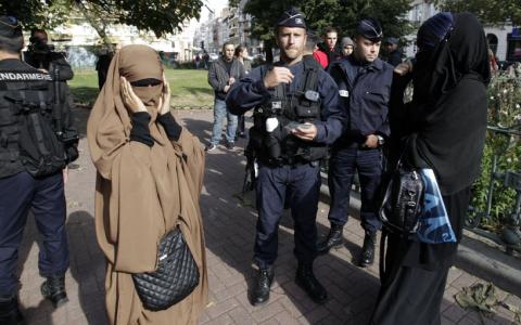 French police and gendarmes check identity cards of two women for wearing full-face veils, or niqab, as they arrived to demonstrate after calls on the internet by Islamic groups to protest over an anti-Islam video, in Lille, September 22, 2012. PHOTO BY REUTERS/Pascal Rossignol