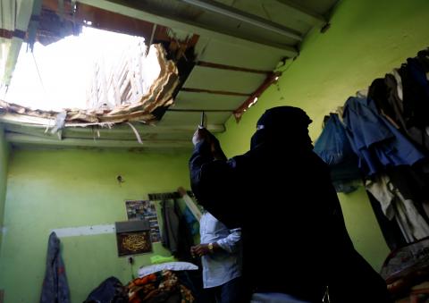 A woman uses her mobile phone to take picture of the damage created by debris, after ballistic missiles fired by Yemen's Houthi militia, fell at a house in Riyadh, Saudi Arabia, March 26, 2018. PHOTO BY REUTERS/Faisal Al Nasser