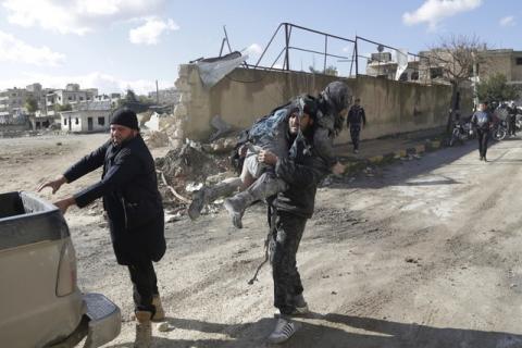 A man carries an injured woman in a site hit by what activists said were airstrikes carried out by the Russian air force in the rebel-controlled area of Maaret al-Numan town in Idlib province, Syria, January 9, 2016. PHOTO BY REUTERS/Khalil Ashawi