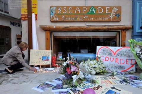 A woman places a candle near flowers and messages outside the mountain guides bureau in tribute to Frenchman Herve Gourdel, in Saint-Martin-Vesubie, September 25, 2014. PHOTO BY REUTERS/Patrice Masante