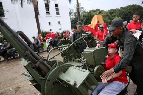 A member of the National Bolivarian Armed Forces teaches a woman how to use an anti-aircraft gun during a military exercise in Caracas, Venezuela, August 26, 2017. PHOTO BY REUTERS/Andres Martinez Casares