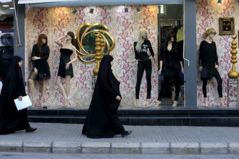 Shi'ite Muslim women walk past mannequins displaying black clothing in Nabatieh, southern Lebanon, October 17, 2015. PHOTO BY REUTERS/Ali Hashisho