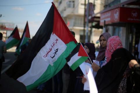Women hold Palestinian flags as they celebrate after rival Palestinian factions Hamas and Fatah signed a reconciliation deal, in the central Gaza Strip, October 12, 2017. PHOTO BY REUTERS/Ibraheem Abu Mustafa