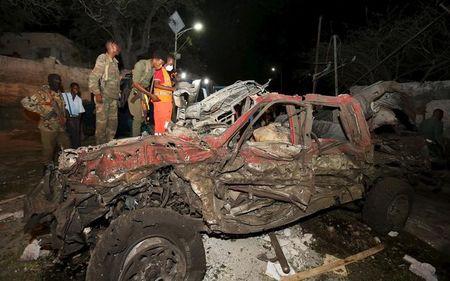 Somali government soldiers look at the wreckage of a car at the scene of an explosion in front of the presidential palace in the capital Mogadishu, September 21, 2015. PHOTO BY REUTERS/Feisal Omar