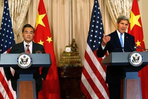 U.S. Secretary of State John Kerry (R) delivers remarks as China's Foreign Minister Wang Yi (L) looks on, before their meeting at the State Department in Washington, October 1, 2014. PHOTO BY REUTERS/Jonathan Ernst