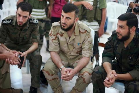 Zahran Alloush (C), commander of Jaysh al Islam, sits during a conference in the town of Douma, eastern Ghouta in Damascus, Syria, August 27, 2014. PHOTO BY REUTERS/Bassam Khabieh