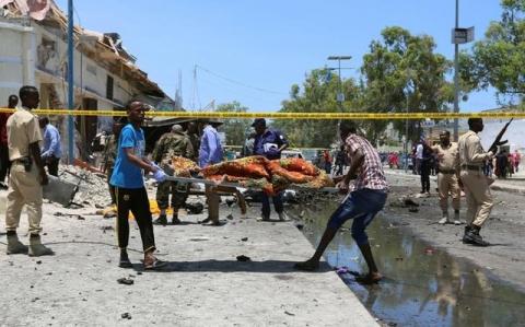 People carry the body of a man killed after a suicide car bomb went off at the entrance of a cafe near compounds housing government ministries in the Somali capital Mogadishu, April 5, 2017. REUTERS/Feisal Omar