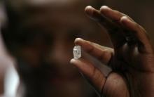 A visitor holds a 17 carat diamond at a Petra Diamonds mine, January 22,2009. PHOTO BY REUTERS/Siphiwe Sibeko