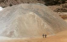 Workers walk past a pile of limestone at the Dangote Cement mine in a file photo. PHOTO BY REUTERS/Akintunde Akinleye