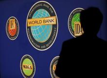 A man is silhouetted against the logo of the World Bank at the main venue for the International Monetary Fund (IMF) and World Bank annual meeting in Tokyo, Japan October 10, 2012. PHOTO BY REUTERS/Kim Kyung-Hoon