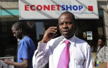 A Zimbabwean man speaks on his phone outside a branch of mobile service provider Econet Wireless in central Harare, June 6, 2014. PHOTO BY REUTERS/Philimon Bulawayo