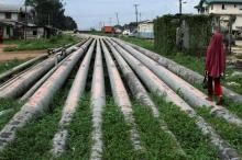 A girl walks on a gas pipeline running through Okrika community near Nigeria's oil hub city of Port Harcourt, December 4, 2012. PHOTO BY REUTERS/Akintunde Akinleye