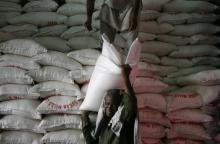 A man unloads a sack of sugar from a warehouse supply in Karachi, April 10, 2010. PHOTO BY REUTERS/Athar Hussain
