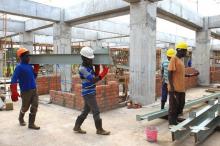 Construction workers move building material on the site of a new hospital in Hoima town, Uganda, April 27, 2015. PHOTO BY REUTERS/James Akena